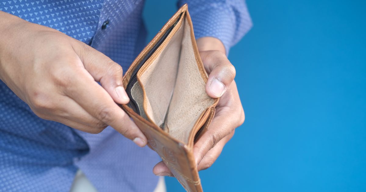Close-up of hands holding an empty wallet, symbolizing financial challenges.