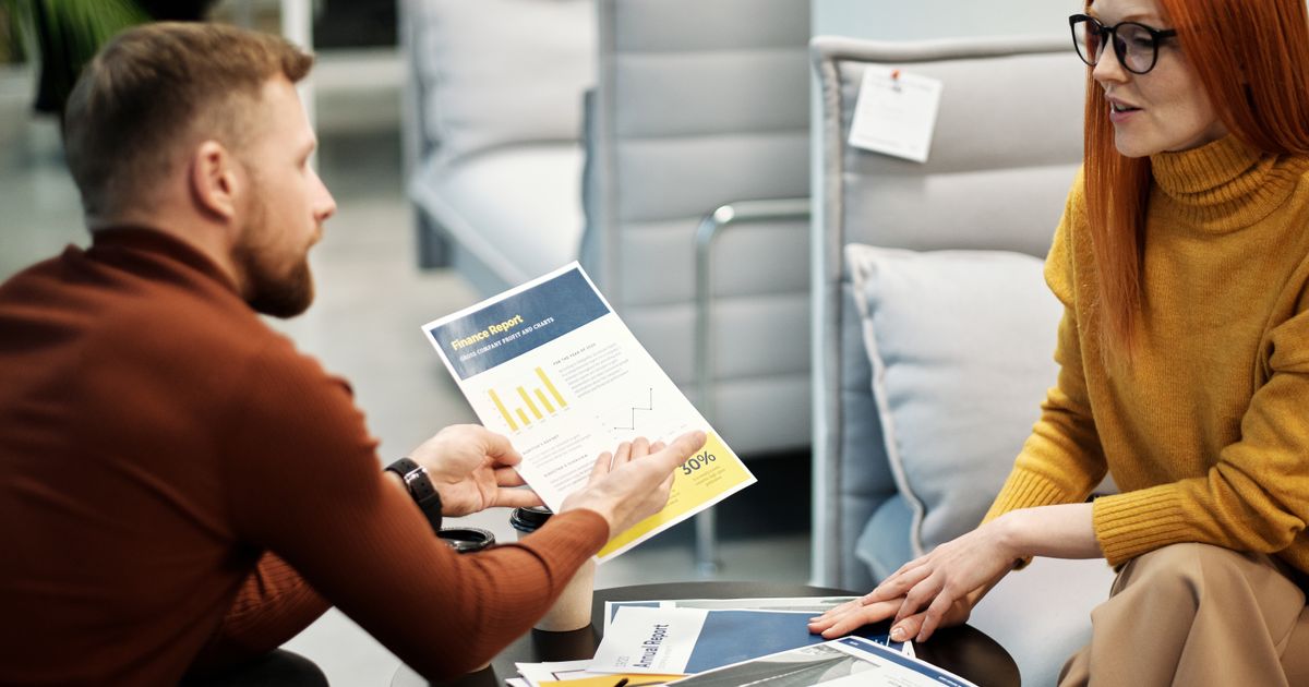 Colleagues discussing financial documents during an office meeting. Professional teamwork setup.